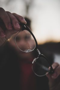 man holding pair of glasses